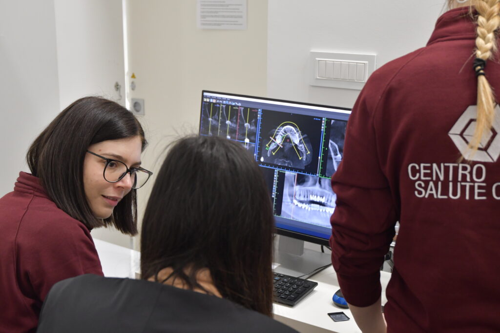 Dentista mostra radiografia dentale a paziente durante visita odontoiatrica in studio a Rimini