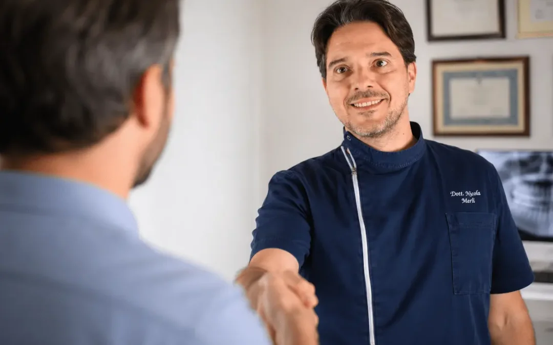 Il dott. Nicola Merli stringe la mano a un paziente durante una consulenza di odontoiatria legale presso il Centro Salute Orale di Bologna e Rimini.