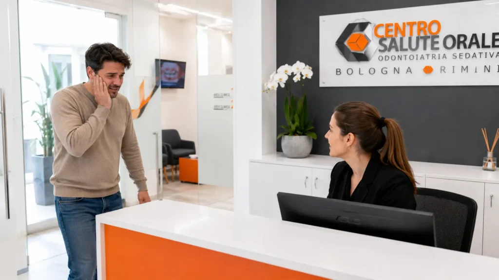 Paziente con dolore dentale acuto accolto dalla segreteria del Centro Salute Orale di Rimini per un'urgenza odontoiatrica. Reception moderna e organizzazione immediata della visita urgente.